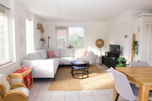 a living room with a white couch and a table at Hello Zeeland - Vakantiehuis Dunen260 in Breskens