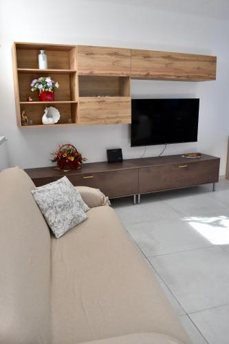 a living room with a couch and a flat screen tv at Cheryl Guest House in Ranco