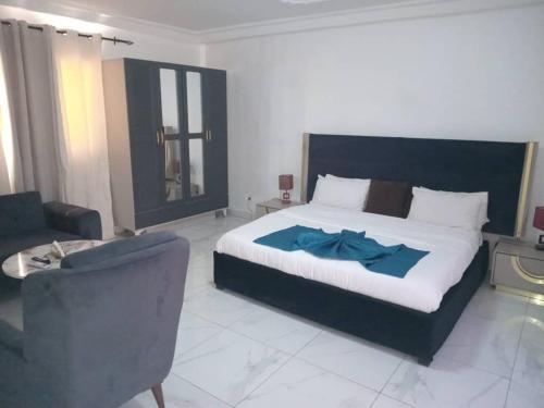 a bedroom with a bed and a couch and a chair at Bi-Hotel 1 in Dakar