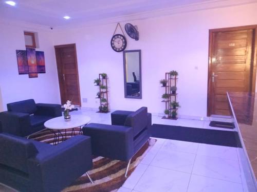 a living room with blue couches and a table and a clock at Bi-Hotel 1 in Dakar