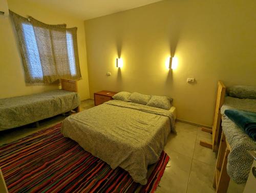 a small bedroom with two beds and a window at אשראם בכרמל - המקום של אורי in Dāliyat el Karmil