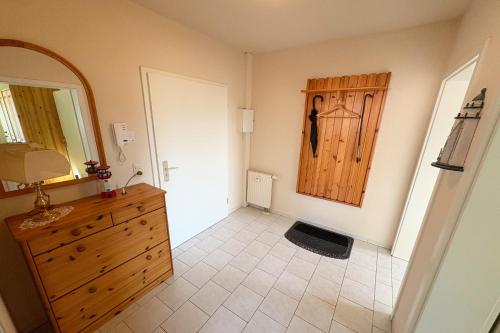 een badkamer met een houten dressoir en een houten deur bij Cölpinstrasse Ferienwohnung Ostseeblume in Kolpinsee