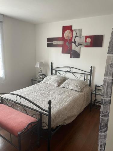 une chambre avec un lit et deux tableaux au mur dans l'établissement Maison agréable de 51 m2, à Cuts