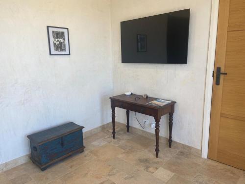 a room with a table and a television on a wall at LIAPIS ESTATE Rostrevor Adelaide in Adelaide