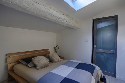 une chambre avec un lit et une lucarne dans l'établissement Jolie duplex au cœur de saint Michel, à Bordeaux