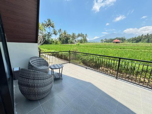a balcony with a view of a rice field at Lombok Hidden Villa in Tetebatu