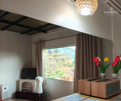 a room with a window and a table with flowers at อากาศดีเขาค้อ akardd khaokho in Khao Kho
