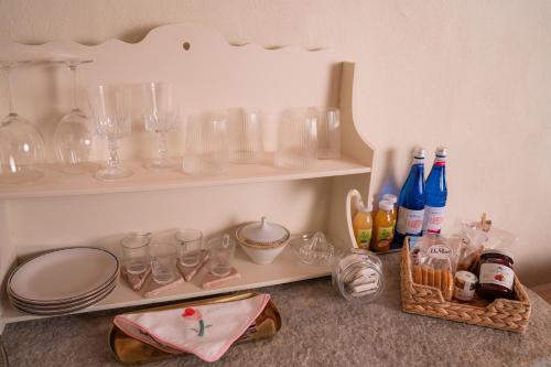 a shelf with glasses and wine glasses and bottles at Villa Bruno Selvago in Lessona in Lessona