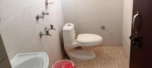 a bathroom with a white toilet and a sink at Hotel Vasavi Naimisharanya in Naimishāranya