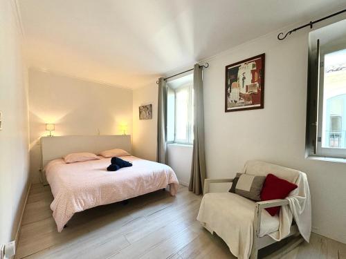 une chambre avec un lit, une chaise et une fenêtre dans l'établissement Le Saint Antoine, Centre Ville, 2 chambres, Clim, à Nîmes