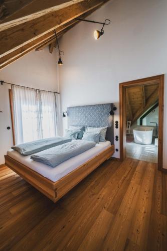 a bedroom with a large bed with a wooden floor at Schmiedgut Bad Aussee in Bad Aussee