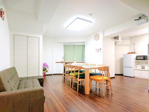 a living room with a table and chairs and a couch at YayoiHotel in Tokyo