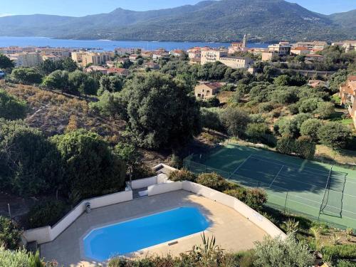 une vue aérienne d'une piscine et d'un court de tennis dans l'établissement Appartement avec vue panoramique sur le Golf de Propriano, à Propriano