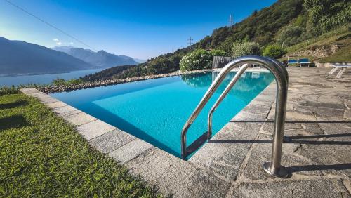 a swimming pool with a metal rail next to a lake at Casa Sorel : Attico Lago & Pool in Pianello Del Lario