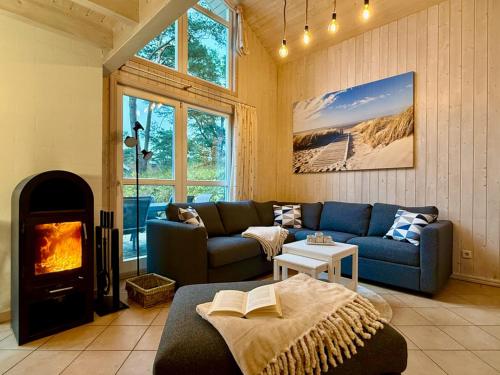 a living room with a blue couch and a fireplace at Meeresblume - Baabe in Baabe