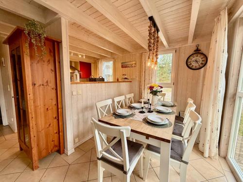 a dining room with a table and chairs and a clock at Meeresblume - Baabe in Baabe
