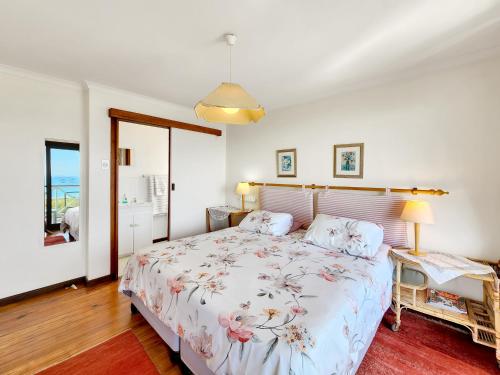 Un dormitorio con una cama con una colcha floral. en Eindelik, en Simonʼs Town