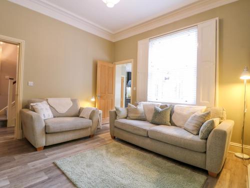 a living room with a couch and a chair and a window at Molly's Way in Melton Mowbray
