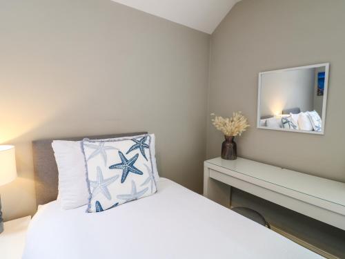 a bedroom with a bed with a pillow and a mirror at Molly's Way in Melton Mowbray