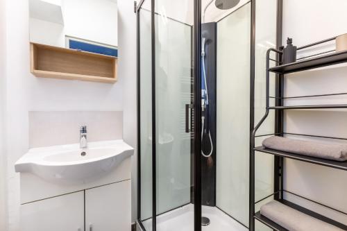 a bathroom with a sink and a shower at La salamandre, 2 people, ground floor, free Wi-Fi in Roncq