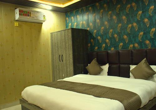 a bedroom with a large bed with a head board at Ganga Riverfront Rooms And Banquet in Prayagraj