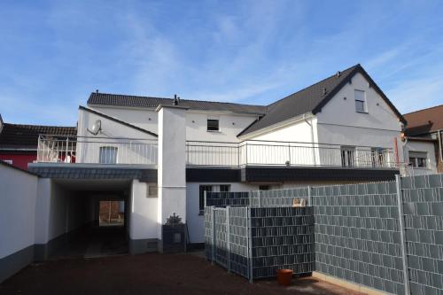 a white house with a fence in front of it at Pension Zur Traube in Bergheim
