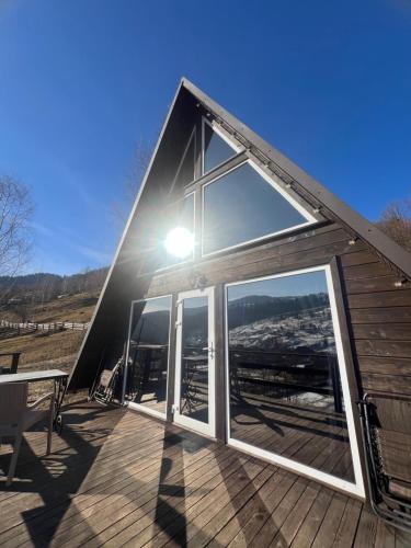 a large glass door on a cabin with a deck at Файна хата 3 in Synevyrsʼka Polyana