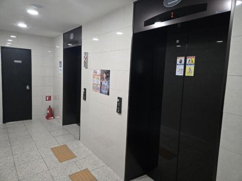 a hallway with black and white stalls in a building at Ulsan Shimpo KCC Residence in Ulsan