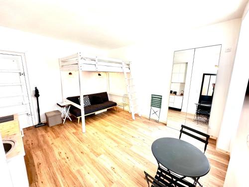 une chambre avec un lit, une table et des chaises dans l'établissement Sunny Paris studio in the heart of 11ème, à Paris