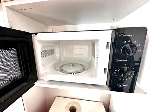 - un four micro-ondes avec une porte ouverte à côté des toilettes dans l'établissement Sunny Paris studio in the heart of 11ème, à Paris