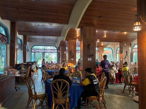 a group of people sitting at tables in a restaurant at Royal Mekong Riverside Hotel in Nong Khai