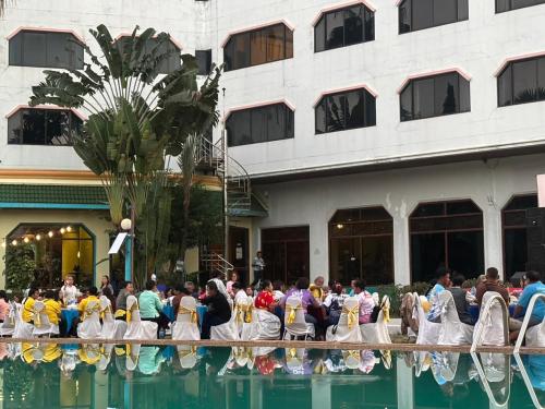 a group of people dressed in mermaid costumes standing around a pool at Royal Mekong Riverside Hotel in Nong Khai