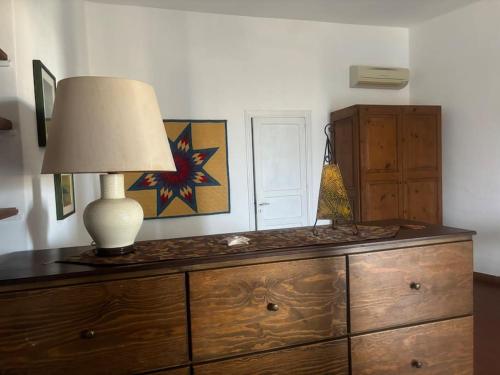 a wooden dresser with a lamp on top of it at Vacanze Salina Monolocale vista mare in Lingua
