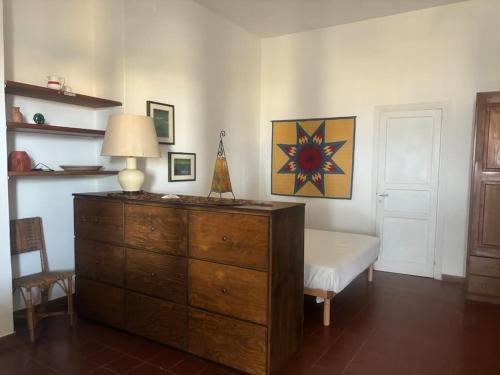 una camera da letto con cassettiera, lampada e sedia di Vacanze Salina Monolocale vista mare a Lingua