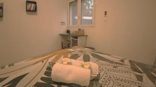 サン・ルにあるLe Voyageur - Chambre chez l'habitantのタオルが敷かれたベッドのある寝室