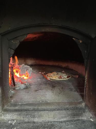 a pizza is cooking in a brick oven at 2 or 4-person apartment CasaDaEfde in Cingoli