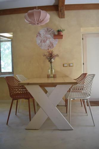a table with chairs and a vase of flowers on it at 2 or 4-person apartment CasaDaEfde in Cingoli