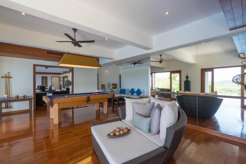a living room with a couch and a pool table at Vichuda Hills by RESAVA in Layan Beach