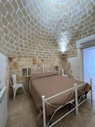a bedroom with a bed and a brick wall at Trulli San Pietro in Putignano