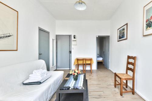 un salon avec un canapé blanc et une table dans l'établissement Stunning 1BR Flat near Vieux Port, à Marseille
