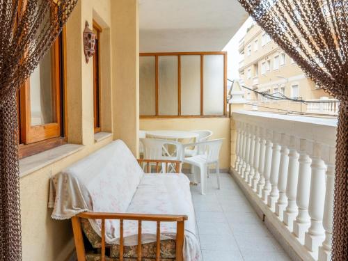 a balcony with a bench and a table and windows at Apartamento Pinzón in Moncófar