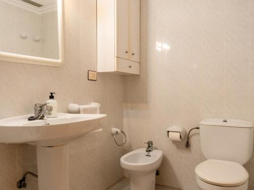 a white bathroom with a sink and a toilet at Apartamento Pinzón in Moncófar