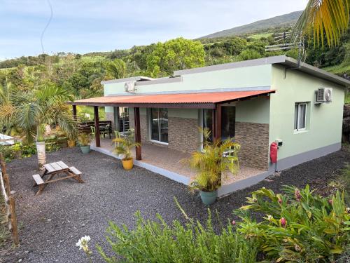 a house with a patio and a table at Ferme auberge le Ti'planteur in Saint-Philippe