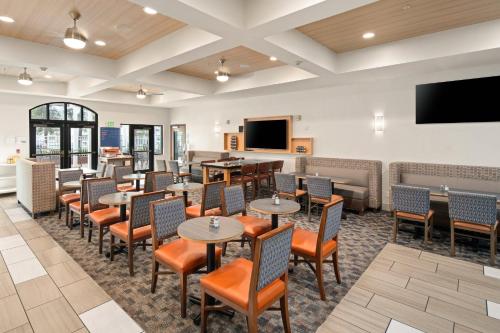 a restaurant with tables and chairs and a flat screen tv at Holiday Inn Express Hotel & Suites Coeur D'Alene I-90 Exit 11 by IHG in Coeur d'Alene