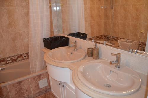 bagno con lavandino, vasca e lavandino di Alegre Apartamento a Cascais