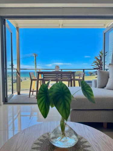 a living room with a vase on a table at Merewether By The Beaches Newcastle, Free Parking, Ocean View in Newcastle
