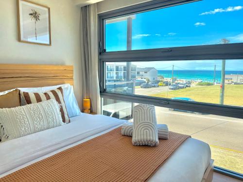 a bedroom with a bed and a large window at Merewether By The Beaches Newcastle, Free Parking, Ocean View in Newcastle