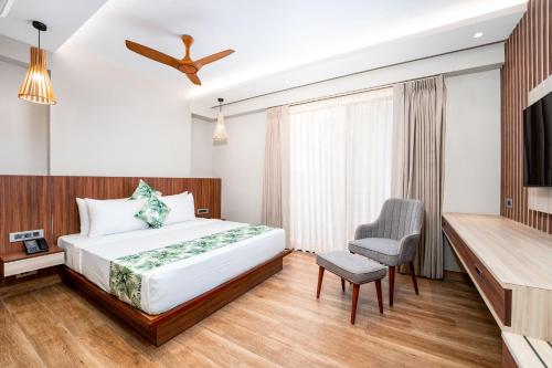 a hotel room with a bed and a chair at Holitel Anjuna in Arpora
