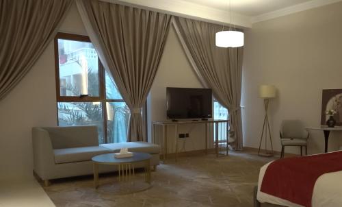 a living room with a bed and a couch and a tv at La Zona Continental Hotel in Dubai