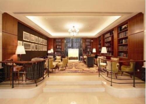 a library with bookshelves and tables and chairs at Jin Jiang Hotel Shanghai - historical hotel in the city-center of Huaihai shopping area and convenient access to metro lines in Shanghai